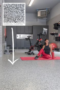 a woman is sitting on the floor in a garage with exercise equipment and an exercise mat