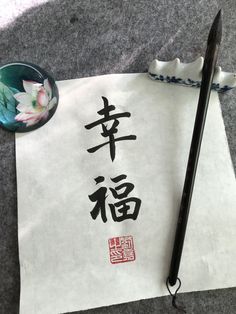 a piece of paper with chinese writing on it and a pen next to it,