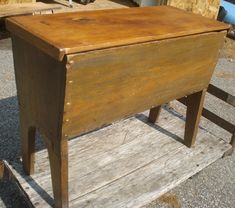 an old wooden desk sitting on top of a pallet