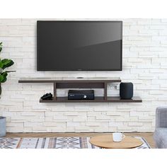 a flat screen tv mounted to the side of a white brick wall