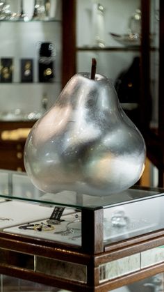 a glass and metal object on top of a table in a room filled with other items