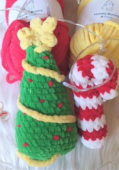 several knitted christmas trees and balls of yarn