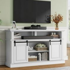 a flat screen tv mounted to the side of a white entertainment center in a living room