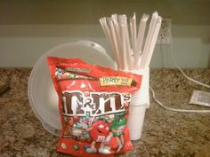 a bag of m & m's sitting on top of a counter next to a plate