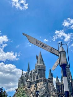 a street sign in front of a castle with hogwarts on it's side