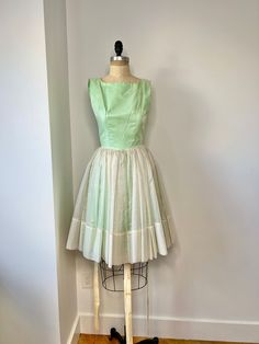 "1950s mint green and white fit & flare mini dress with textured polka dot overlay. This dress is so, so cute!! It is not a low back dress, the dress was a bit small on my mannequin and so is not fully zipped.  In very good vintage condition B: 32\" W: 25\" L:  31.5\"" 1950s Style Green A-line Dress, 1950s Style Sleeveless Green Dress, 1950s Style Lined Dress With Full Skirt, 1950s Style Dress With Full Skirt And Lining, 1950s Vintage Summer Dress, 1950s Fitted Bodice Vintage Summer Dress, 1950s Style Vintage Dress With Fitted Bodice For Summer, 1950s Style Green Vintage Dress For Spring, Vintage Green Dress With Full Skirt