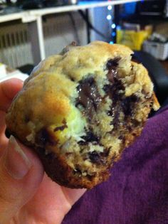 a person holding a chocolate chip cookie in their hand