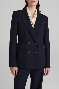 A versatile, all-season wardrobe Essential, the First Class Navy Charmer Blazer in a light wool-mohair blend shows sharp shoulders and a waist-cinching slim fit. It layers over any look or pairs as a suit with the coordinating pants. Designed for a slim fit, hourglass shape Double-breasted Lightly padded shoulders Navy lining Glossy loden inspired buttons Peak lapels Smiley outer pockets and one internal pocket 71% Virgin Wool 29% Mohair Lining: 100% Viscose Made in Italy SIZE CHART0 = XS1 = S2 Timeless Fitted Double Breasted Suit For Work, Chic Wool Suits For Office Wear, Chic Wool Suits, Fitted Double Breasted Suit With Concealed Placket For Fall, Fitted Structured Double-breasted Suits, Chic Wool Suits For Business Casual, Chic Business Casual Wool Suits, Chic Fitted Double Breasted Suit With Buttons, Chic Fitted Double Breasted Suit