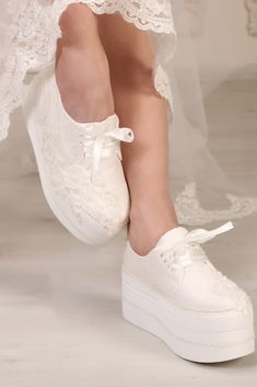 a close up of a person's white shoes with lace on the top and bottom