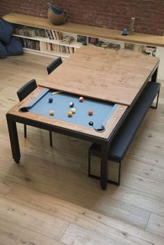 a table with a pool on it in a living room next to a book shelf