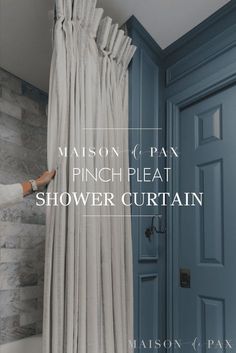 a woman is opening the pinch plea shower curtain in front of a blue door with text reading mason & pan pinch plea shower curtain