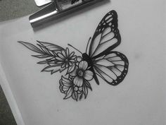 a black and white photo of a butterfly with flowers on it's back side