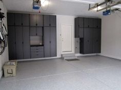 an empty garage with gray cabinets and white walls