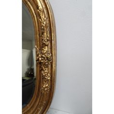 an ornate gold framed mirror against a white wall