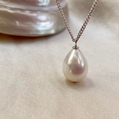 A stunning single pearl pendant necklace, on a sterling silver chain. * 13mm x 10mm teardrop freshwater pearl  * 16"/40cm fine sterling silver chain (not your length? message me) * boltring clasp * classic minimalist design  A truly beautiful white freshwater pearl with natural pink colours in its fabulous lustre. This perfect teardrop shaped pearl has natural banding which only adds to its unique allure.  Hanging from a recycled sterling silver curb chain, this pearl pendant necklace is perfect Minimalist Teardrop Pearl Drop Necklace, Pearl Drop Teardrop Necklace, Elegant Teardrop Drop Necklace With Pearl Charm, Minimalist Pearl Drop Teardrop Necklace, Elegant Drop Necklace With Pearl Chain And Teardrop Pendant, Minimalist Pearl Pendant Drop Necklace For Formal Occasions, Sterling Silver Pear Shaped Drop Necklace For Formal Occasions, Formal Sterling Silver Pear Drop Necklace, Pear Shaped Sterling Silver Drop Necklace For Formal Occasions