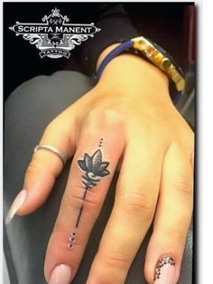 a woman's hand with a small tattoo on it