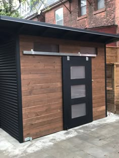 a small wooden building sitting on top of a sidewalk