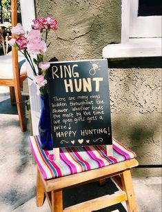 a sign on a chair that says ring hunt and flowers in a vase next to it