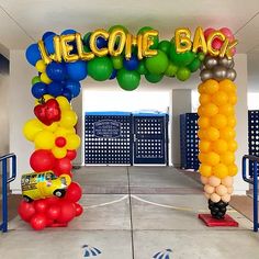 an entrance decorated with balloons and welcome signs