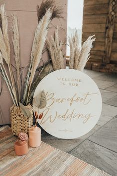 the welcome sign is next to some flowers and candles