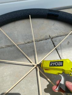 a person is holding a wrench near a spoke on the ground with sticks sticking out of it