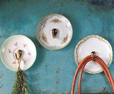 three teacups and saucers with handles on a blue tablecloth covered wall