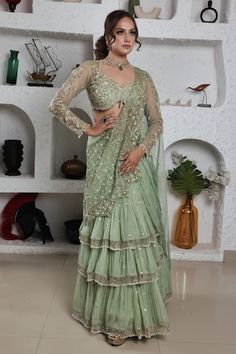 Pista green layered pre-drape saree skirt with an attached cancan and jaali tassels. Comes with a tulle padded blouse and organza drape embedded with sequins, cutdana and glass beads, dabka and pearls. - Aza Fashions Draped Saree Gown, Ruffled Saree, Vani Vats, Cotton Sarees Handloom, Ruffle Sarees, Draped Saree, Embroidery Leaf, Cutout Blouse, Ruffle Saree