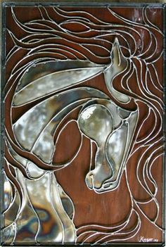 a metal art piece with a horse on it's face in brown and silver