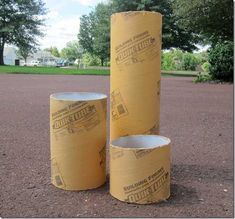 three rolls of toilet paper sitting in the middle of a parking lot next to trees