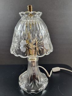 a glass table lamp with a cord plugged into it