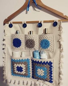 a crocheted wall hanging with blue and white items