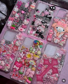 there are many different cell phones in the case with hello kitty decorations on them,