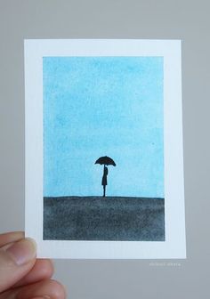 a person holding an umbrella in front of a blue sky