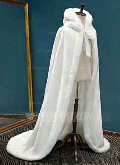 a mannequin with a white fur coat on display in front of a mirror