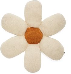 a white and brown flower shaped object on a white surface