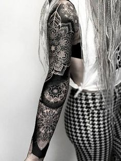 a woman with long white hair and tattoos on her arm