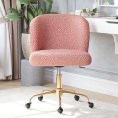 a pink office chair sitting on top of a white rug in front of a desk