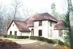 a large white house surrounded by trees and bushes