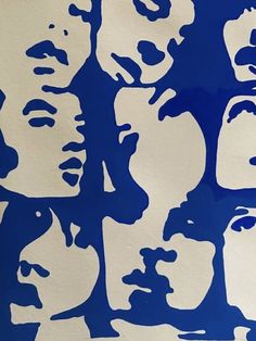 a blue and white painting with many faces