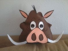 a brown cow with big eyes sitting on top of a couch next to a wall