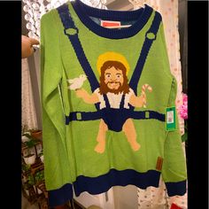 a green sweater with an image of jesus on the front, and a blue belt around the waist