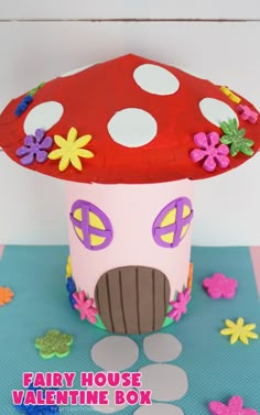 a paper cup with a mushroom house on top and flowers around the base for decoration