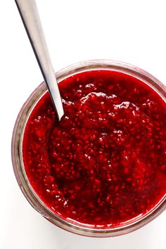 a spoon in a jar filled with red liquid