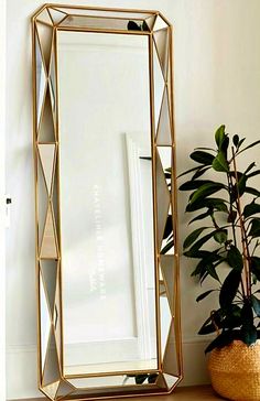 a mirror sitting on top of a table next to a potted plant