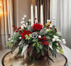 a christmas centerpiece with candles and flowers