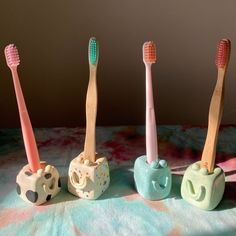 three toothbrushes are lined up in the shape of elephants on a tablecloth