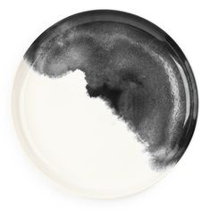 a black and white plate on a white background with some paint splattered over it