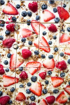 a dessert with strawberries, blueberries and granola on it