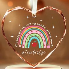 a heart shaped glass ornament with the words teachers life on it and an apple inside