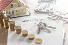 a house, calculator, pen and glasses sitting on top of a paper with the word mortgage next to it